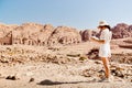 Fashionable caucasian woman tourist, read map, plan exploring the sights of the ancient, fabulous city of Petra in Jordan.