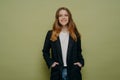 Fashionable cheerful teenage girl with hands in pockets posing in studio Royalty Free Stock Photo