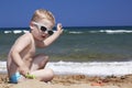 Fashionable Child plays on the beach in sand. litt