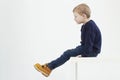 Fashionable child in yellow boots. fashion kids.little boy sitting on a table