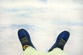 fashionable children sneakers on blurry blue background of cloudy sky