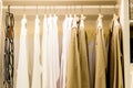 Fashionable clothes hanging on rack at modern dressing room.Toned image.Wardrobe full of Many blouses on hangers in the