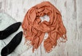 Fashionable concept. Large scarf and black boots. Top view, light wooden background