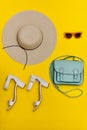 Fashionable concept. Women`s beach hat, handbag, white shoes. Yellow background, top view Royalty Free Stock Photo