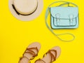 Fashionable concept. Women`s straw hat, Mint handbag, sandals. Yellow background, top view Royalty Free Stock Photo