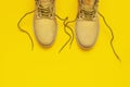 Fashionable concept. Yellow men`s work boots from natural nubuck leather on bright yellow background top view flat lay with copy Royalty Free Stock Photo