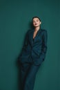 Fashionable confident woman wearing elegant green suit