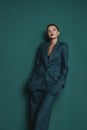 Fashionable confident woman wearing elegant green suit