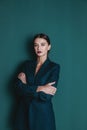 Fashionable confident woman wearing elegant green suit