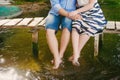 Fashionable cool couple on a bridge near the water, relationships, romance, legs, lifestyle - concept Royalty Free Stock Photo