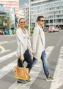 Fashionable couple crossing road at pedestrian zebra crossing Royalty Free Stock Photo