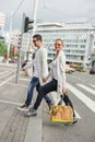 Fashionable couple crossing road at pedestrian zebra crossing Royalty Free Stock Photo