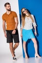 Fashionable couple posing in summer clothes and sunglasses on grey and blue Royalty Free Stock Photo