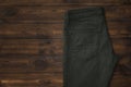 Fashionable dark green men`s jeans on a wooden background.