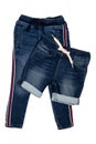 Fashionable denim clothes. Trendy stretch blue jeans trousers and a stylish short jeans pants with white ribbon isolated on a Royalty Free Stock Photo