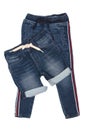 Fashionable denim clothes. Trendy stretch blue jeans trousers and a stylish short jeans pants with white ribbon isolated on a Royalty Free Stock Photo