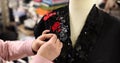 Fashionable designer sews a women black suit or dress in atelier