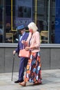Fashionable elderly couple wearing face masks walking down the street