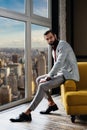 fashionable elegant man in stylish suit posing at window