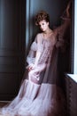 Fashionable female portrait of cute lady in pink dress indoors