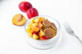 Fashionable food-mini pancakes. A pile of mini cereal pancakes with fruit slices in a glass plate on a white background