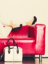 Fashionable girl with bag handbag on red couch Royalty Free Stock Photo