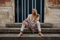 Girl sitting stairs medieval Romanesque door evening sun