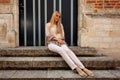 Girl sitting stairs medieval Romanesque door evening sun Royalty Free Stock Photo