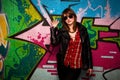 Fashionable girl and colorful graffiti wall