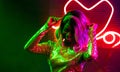 Fashionable girl dancing in night club. Cheerful African American woman dancing among the bright neon lights. Party Royalty Free Stock Photo