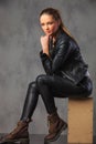 Fashionable girl in leather posing in studio background