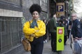 Fashionable girl with a ponytail and yellow jacket walking on Brick Lane