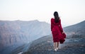 Fashionable girl in red dress on a desert mountain top Royalty Free Stock Photo