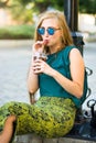 Fashionable girl sitting on the street with coffee to go Royalty Free Stock Photo