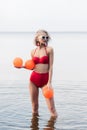 fashionable girl in vintage red bikini and sunglasses posing in water Royalty Free Stock Photo