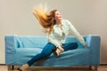 Fashionable girl wearing denim relaxing on couch. Royalty Free Stock Photo