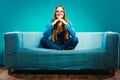 Fashionable girl wearing denim sitting on couch. Royalty Free Stock Photo