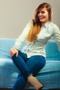 Fashionable girl wearing denim sitting on couch. Royalty Free Stock Photo