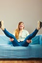 Fashionable girl wearing denim sitting on couch. Royalty Free Stock Photo