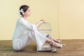 fashionable girl in white with bird in cage sitting on floor Royalty Free Stock Photo