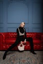 Fashionable glamorous young blond woman in black stylish clothes in an elegant pearl top with a vintage elegant pearl bag poses on Royalty Free Stock Photo