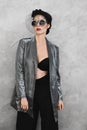 Fashionable half-naked brunette model girl with bright makeup and with stylish hat in an unbuttoned silver jacket, in Royalty Free Stock Photo