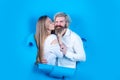 Fashionable happy couple on blue background. Young couple kissing through paper. Surprised man and woman looking through Royalty Free Stock Photo