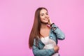 Fashionable happy young woman with cute smile in stylish youth blue jeans clothes posing and beautiful smiling near vintage pink Royalty Free Stock Photo