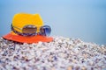 Fashionable hat with glasses are on the sea shells. Concept of tourist recreation on the sea beach