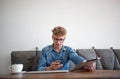 Young man modern businessman reading text message on mobile phone, holding touch pad in hand. Royalty Free Stock Photo