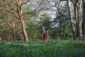Fashionable lady posing in an English wood with bluebells and trees