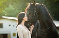 Fashionable lady with white bridal dress near brown horse. Beautiful young woman in a long dress posing with a friendly horse Royalty Free Stock Photo