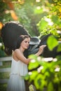 Fashionable lady with white bridal dress near brown horse in nature. Beautiful young woman in a long dress posing with a horse Royalty Free Stock Photo