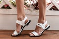 Fashionable leather white summer shoes on female legs
